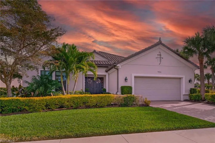 Mediterranean / spanish home with a yard, stucco siding, driveway, a garage, and a tile roof