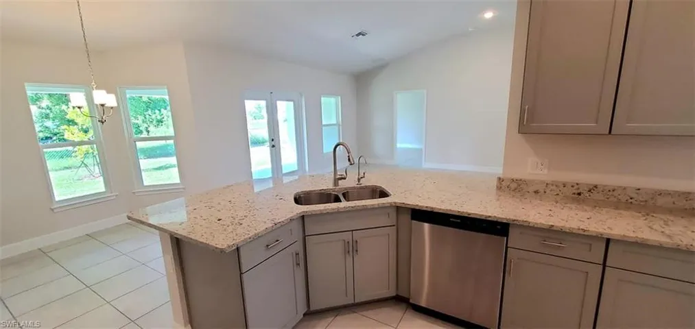 Kitchen featuring dishwasher, kitchen peninsula, sink, and a chandelier