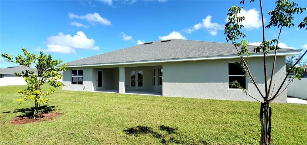 Back of property featuring a lawn and a patio area