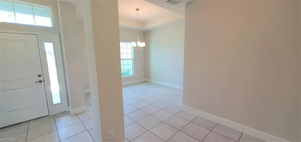 Tiled entrance foyer featuring plenty of natural light and an inviting chandelier
