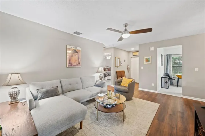 Living room featuring a textured ceiling, ceiling fan, and hardwood / wood-style flooring