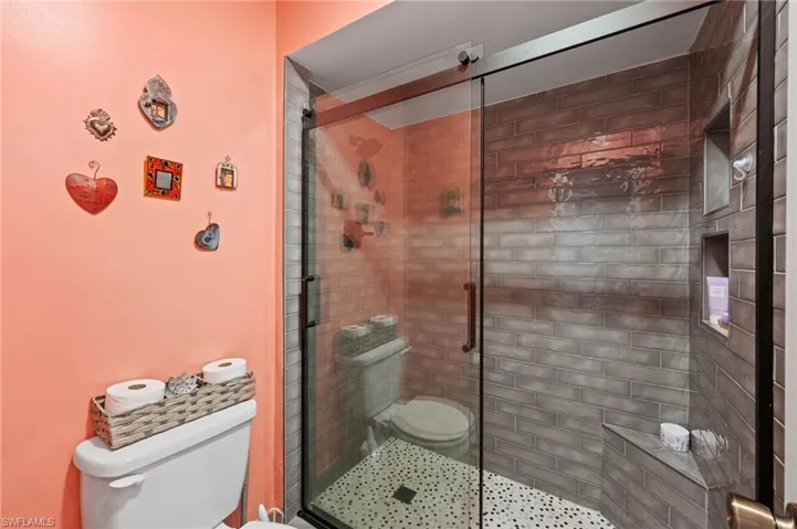 Bathroom featuring toilet and an enclosed shower