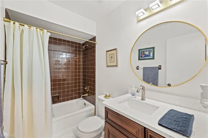 Full bathroom with shower / bath combo, toilet, and vanity