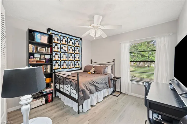 Bedroom featuring a textured ceiling, ceiling fan, and light wood-type flooring