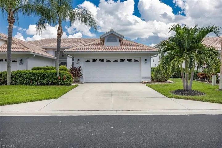 View of front facade featuring a garage and a front yard