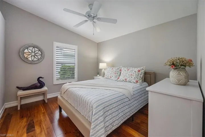 Bedroom 2 with vaulted ceiling, cherry hardwood floors, and ceiling fan