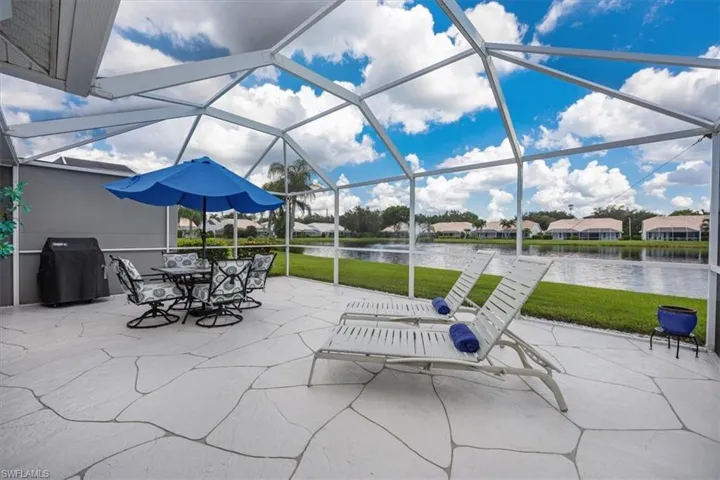 View of patio featuring grilling area, a water view, and screened lanai