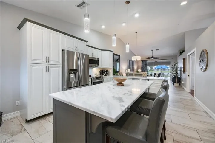 Renovated Kitchen featuring a center island, kitchen peninsula, a kitchen breakfast bar, stainless appliances and ceiling fan