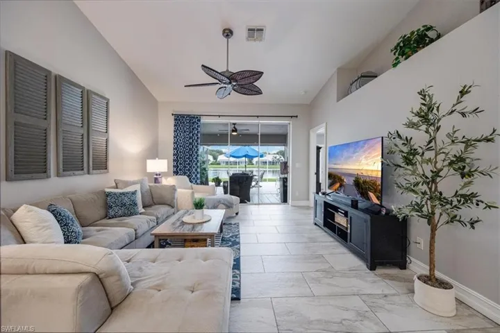 Living room featuring ceiling fan and lofted ceiling