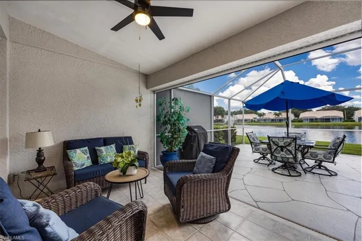 Covered lanai with ceiling fan, screened enclosure, and water view
