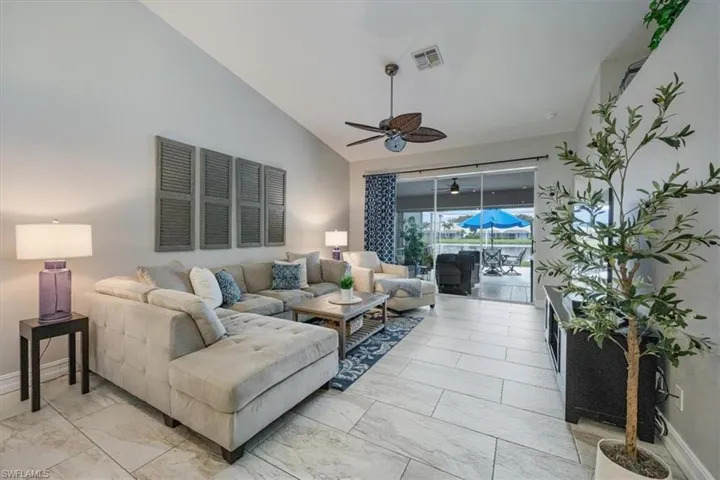 Living room with ceiling fan and lofted ceiling
