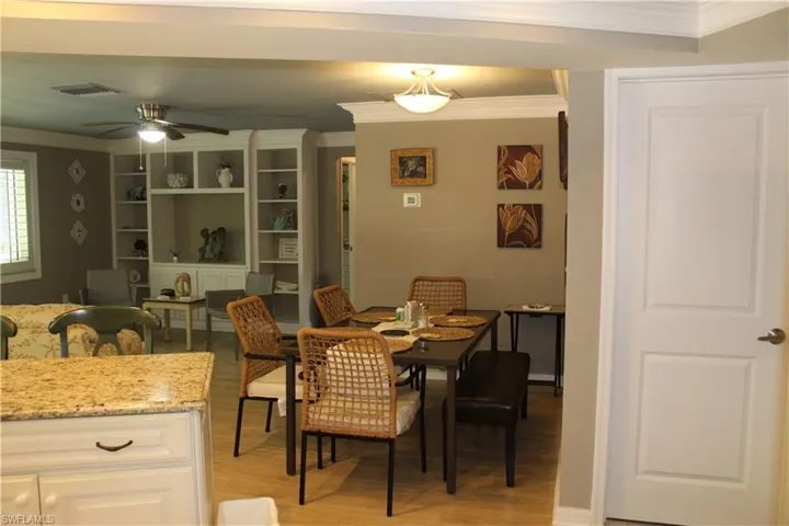 Dining area with crown molding, light wood finished floors, and a ceiling fan