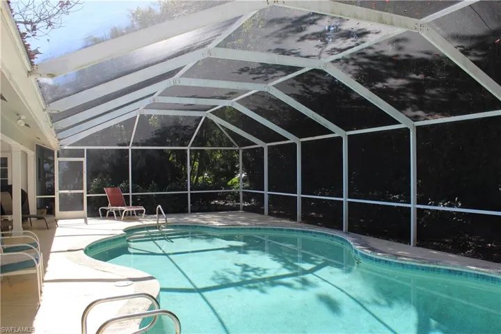 Swimming pool featuring a lanai, a sunroom, and a patio