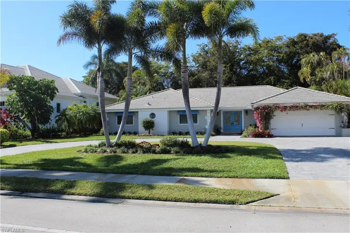Ranch-style house with driveway, a front lawn, french doors, and a garage