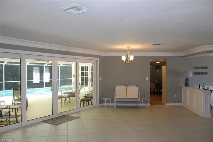 Doorway with crown molding and hanging lights