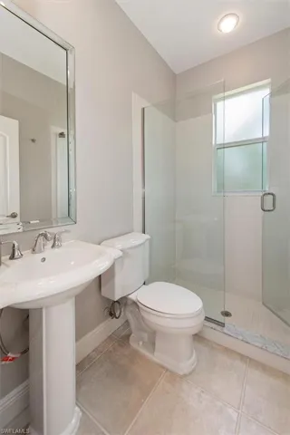 Bathroom with a stall shower and tile patterned floors