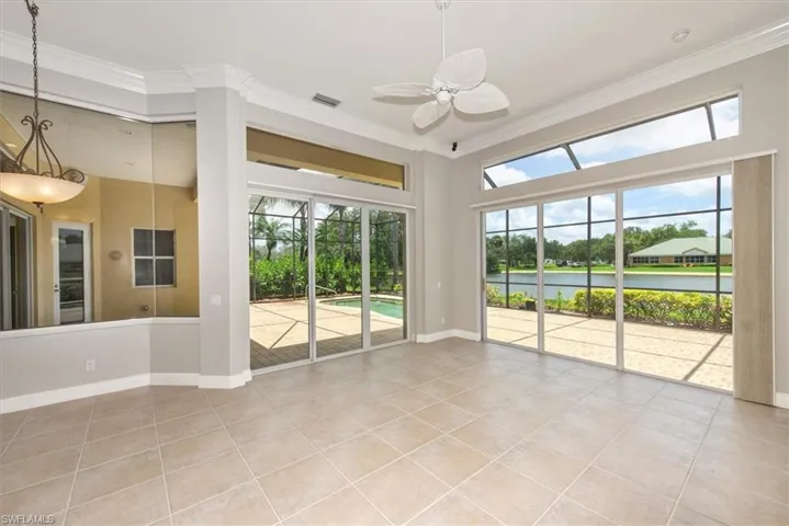 Unfurnished room featuring a ceiling fan, crown molding, and light tile patterned floors