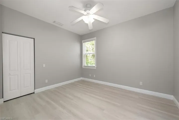 Unfurnished bedroom featuring light wood-style floors, a closet, and a ceiling fan