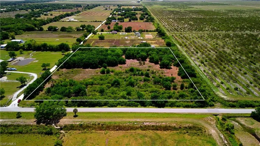 Aerial view of sparsely populated area featuring extensive farmland and property parcel outlined