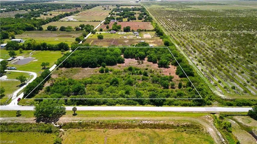 Aerial view of sparsely populated area featuring farmland and property parcel outlined