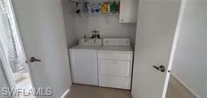 Washroom with washer and clothes dryer and baseboards