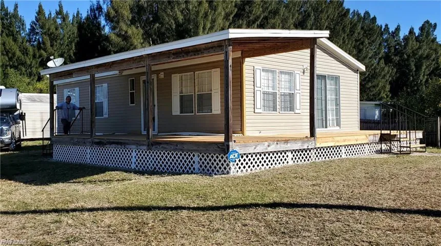 Rear view of house featuring a lawn and a porch