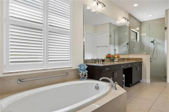 Bathroom featuring tile patterned flooring, vanity, and independent shower and bath