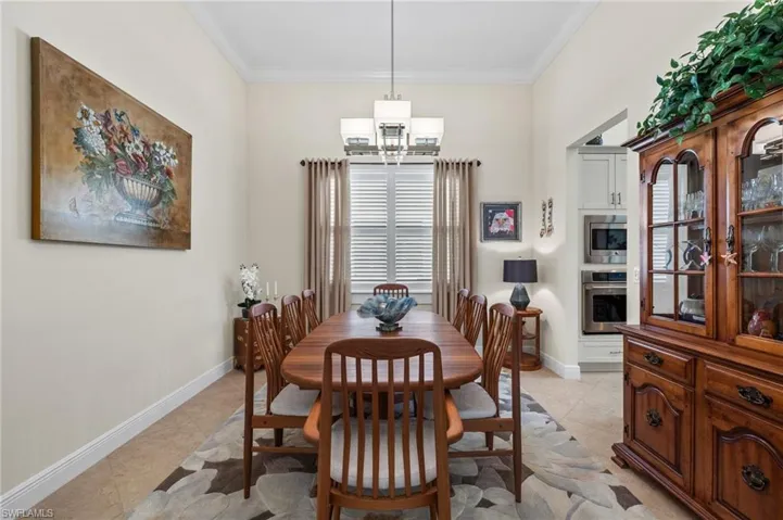 Tiled dining room featuring crown molding and a notable chandelier