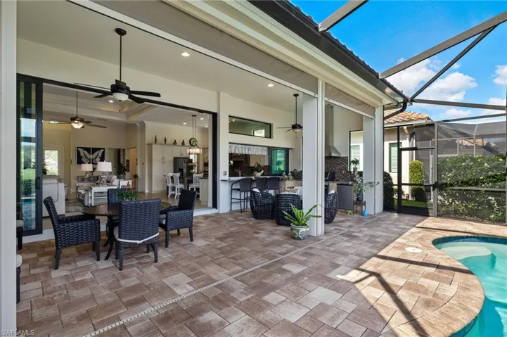 View of patio with ceiling fan and a lanai