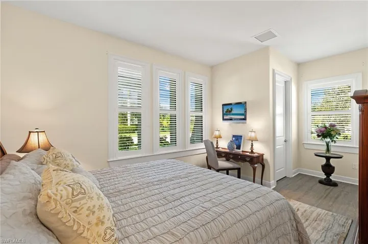 Bedroom with hardwood / wood-style floors and multiple windows
