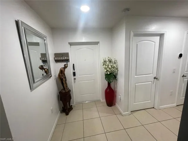 Corridor with light tile patterned flooring