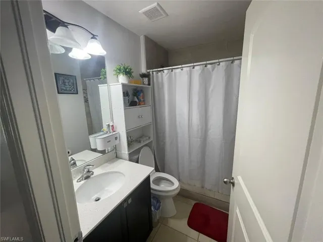 Bathroom with tile patterned flooring, toilet, and vanity