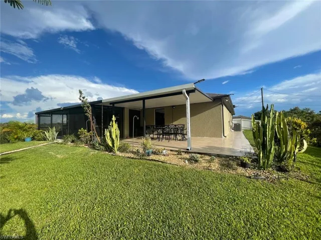 Rear view of house featuring a patio and a lawn