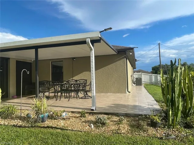 Rear view of house with cooling unit and a patio