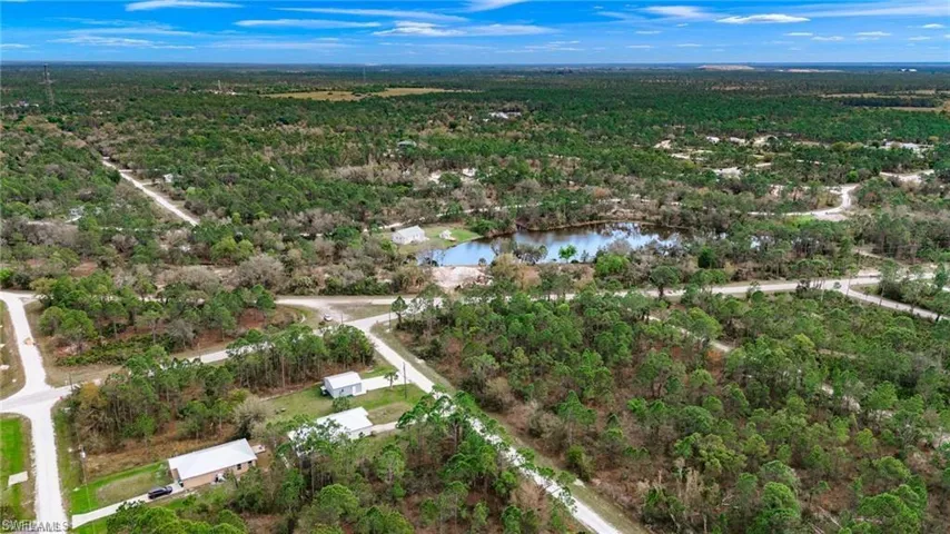 View of property location featuring a heavily wooded area and a nearby body of water