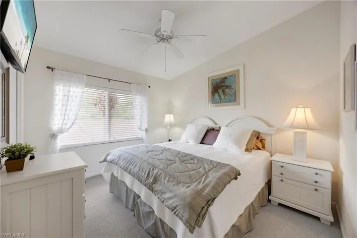 Bedroom with ceiling fan, baseboards, and light carpet