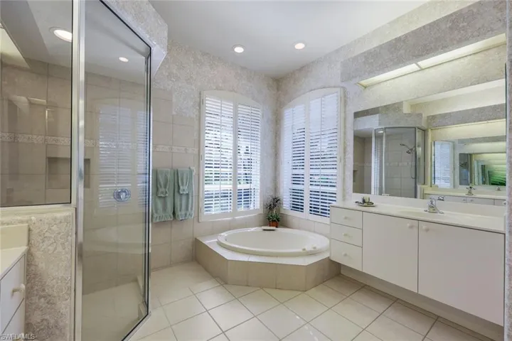 Bathroom with tile patterned flooring, vanity, and independent shower and bath