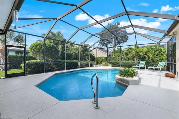 View of swimming pool with glass enclosure and a patio