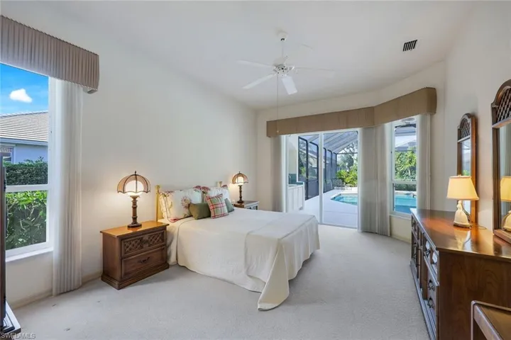 Carpeted bedroom featuring ceiling fan, access to outside, and multiple windows