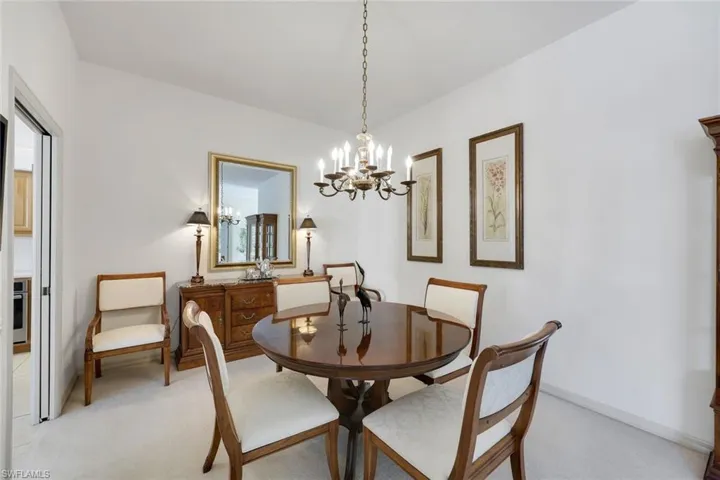 Dining space with light carpet and a notable chandelier