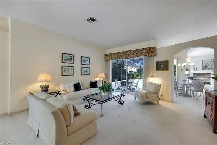 Carpeted living room with an inviting chandelier