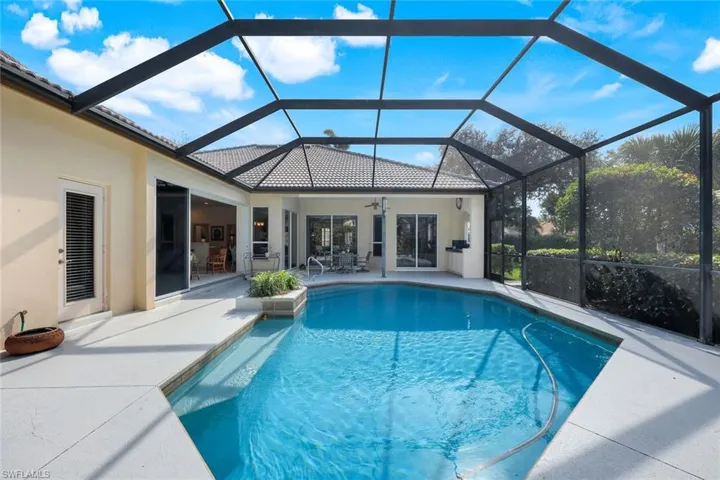 View of pool featuring ceiling fan, a patio, and glass enclosure