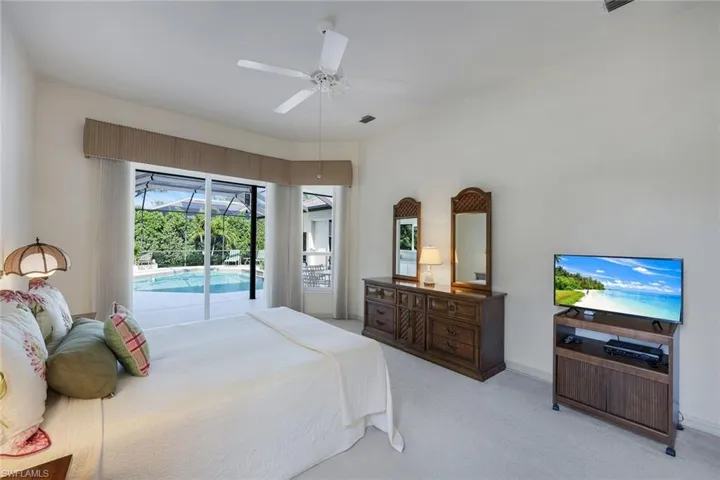 Carpeted bedroom with access to outside and ceiling fan