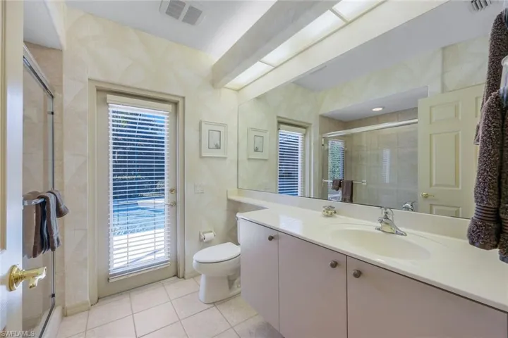 Bathroom featuring tile patterned floors, vanity, toilet, and a shower with shower door