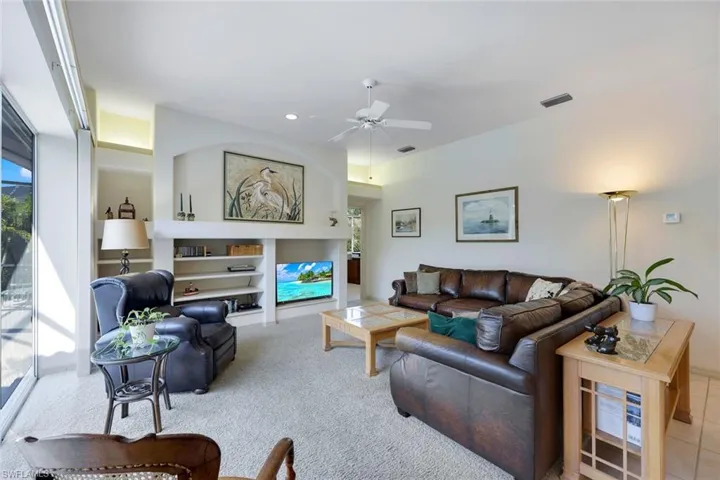 Carpeted living room featuring ceiling fan