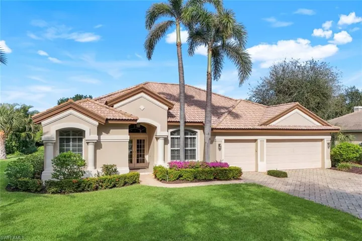 Mediterranean / spanish home featuring a front yard and a garage