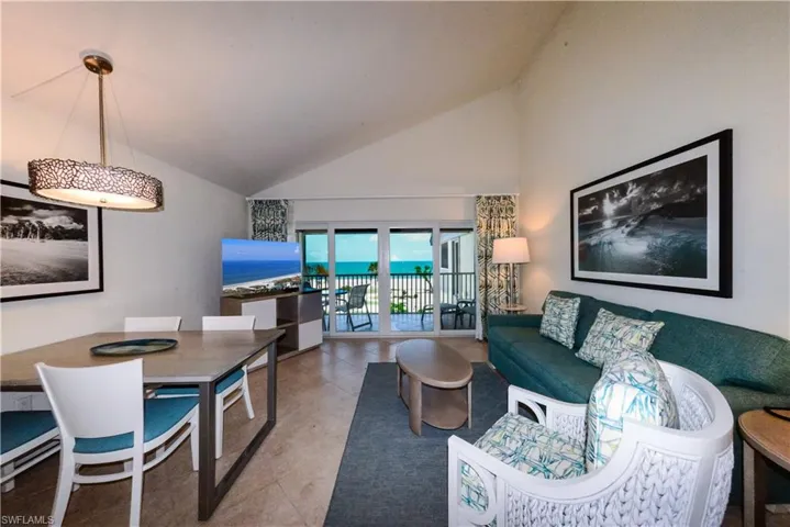 Living area with high vaulted ceiling and light tile patterned floors