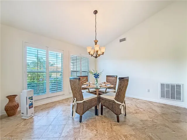 Dining space featuring vaulted ceiling and a chandelier