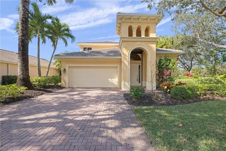 View of front of property with decorative driveway, an attached garage, and stucco siding