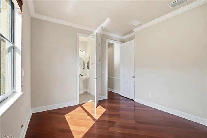 Private downstairs guest ensuite offering decorative molding, wood-style flooring, beautifully appointed connected bath